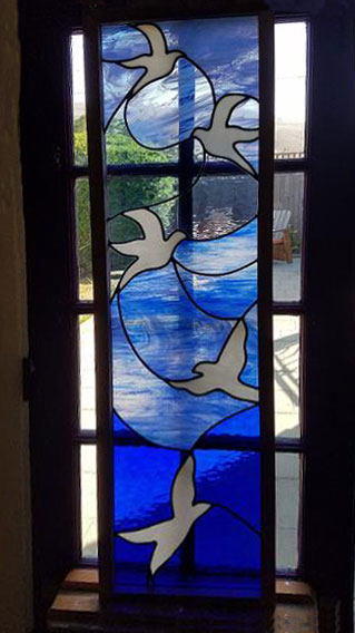 five white birds flying on a blue background Stained Glass